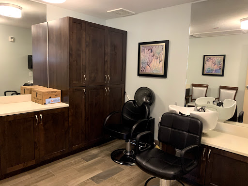 A cozy salon interior featuring stylish chairs, wooden cabinets, and artistic decor.