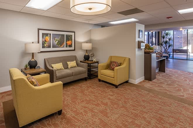 A cozy waiting room with comfortable seating and artwork on the walls.
