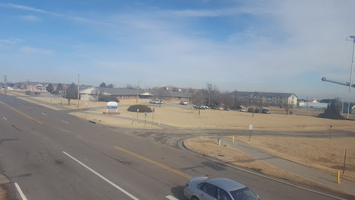 A view of a wide, open area beside a road with clear skies and light cloud cover.