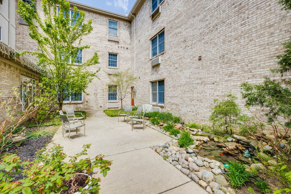 A peaceful courtyard with garden and stone path in a building complex.