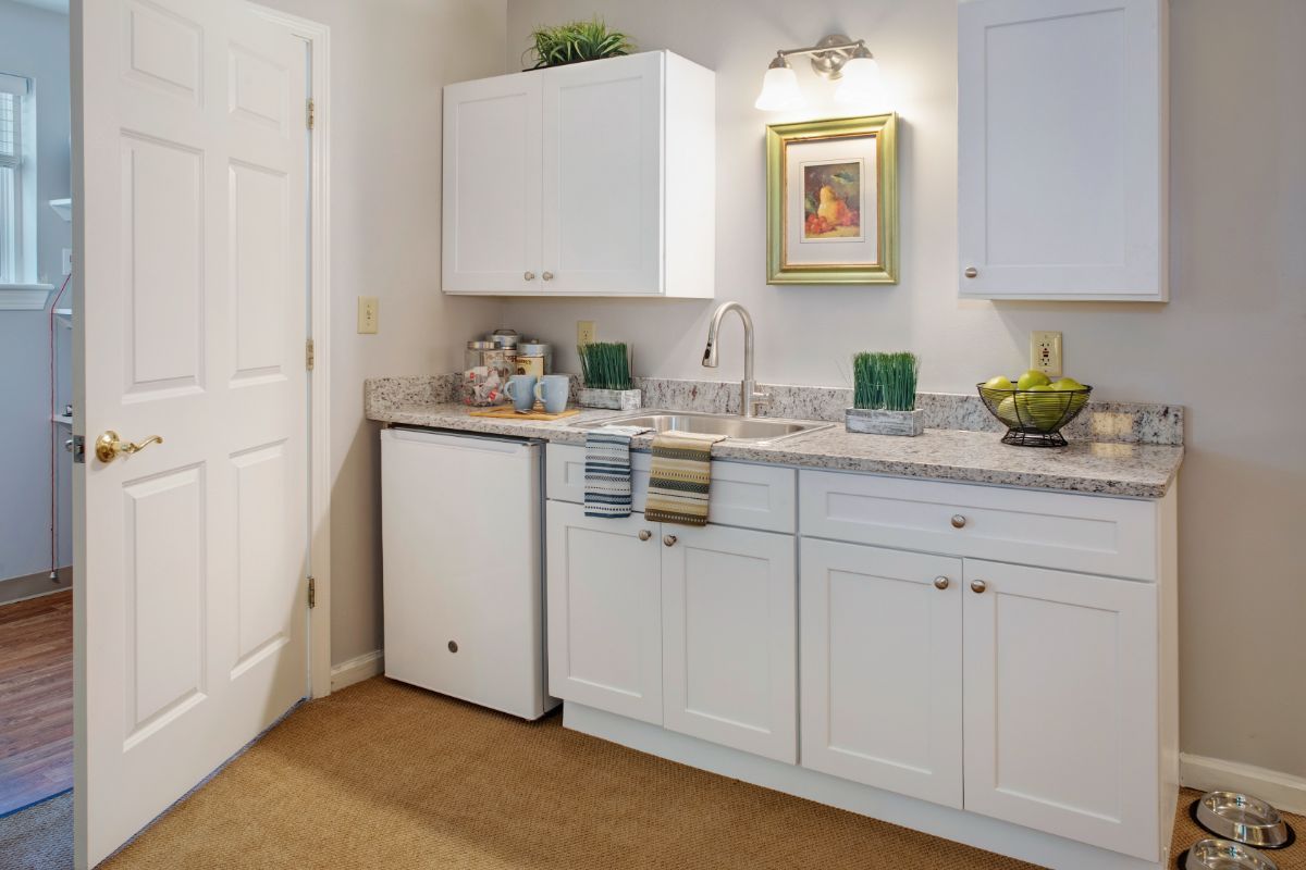 A modern kitchen with white cabinets, a sink, and countertop appliances.