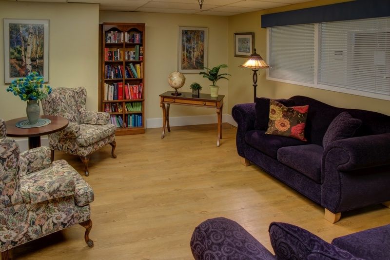 A cozy living room with a bookshelf, plush seating, and decorative elements.