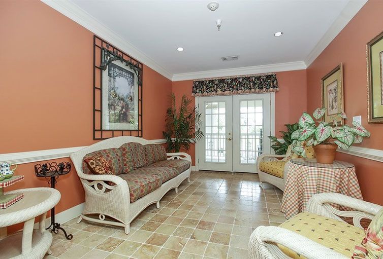 A cozy living room with wicker furniture, vibrant wall color, and decorative elements.