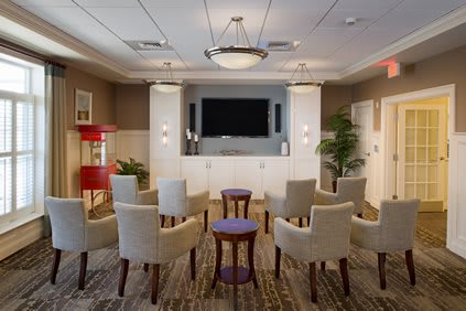 A cozy home theater room with comfortable seating and a large television.