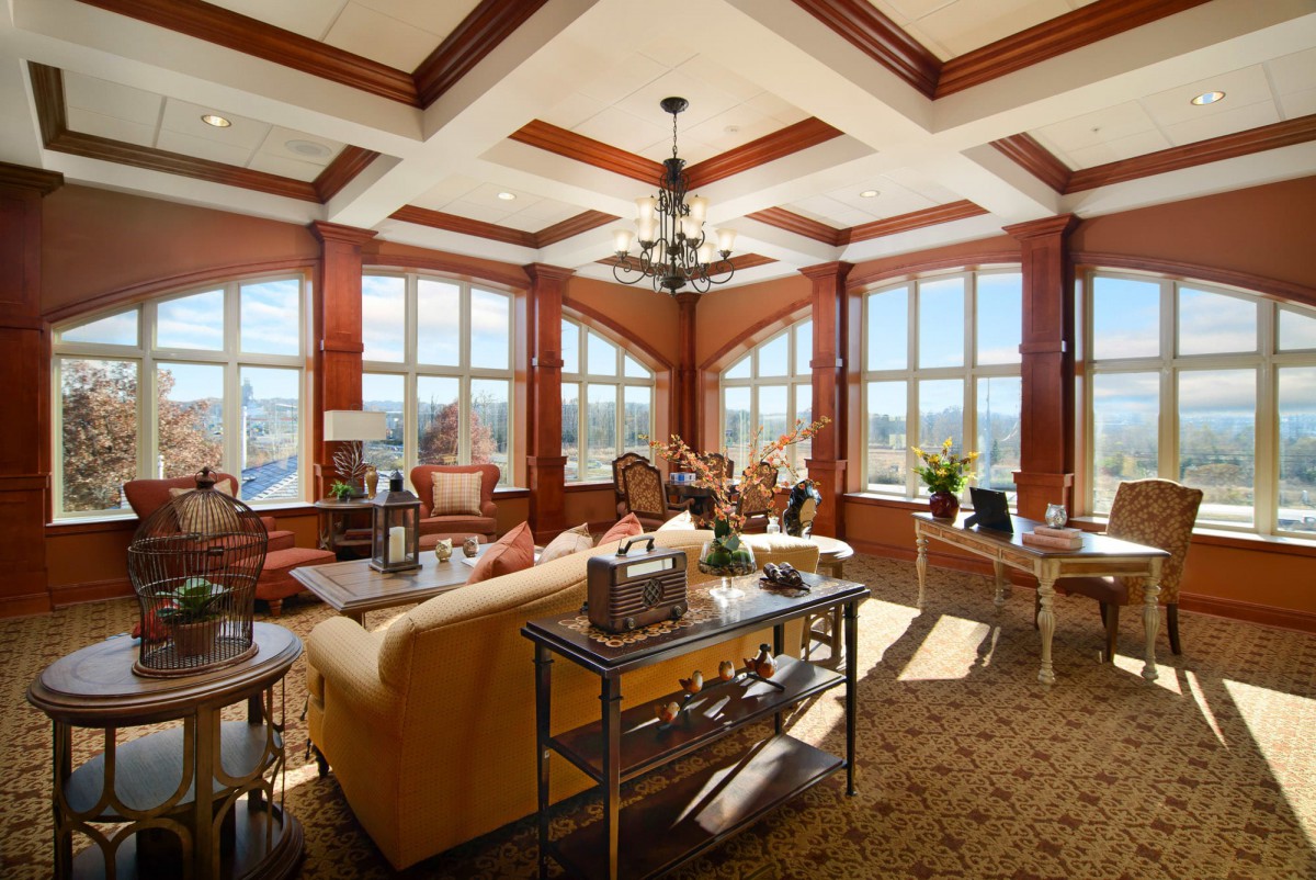 A spacious and elegantly designed living room with large windows allowing natural light to fill the space.