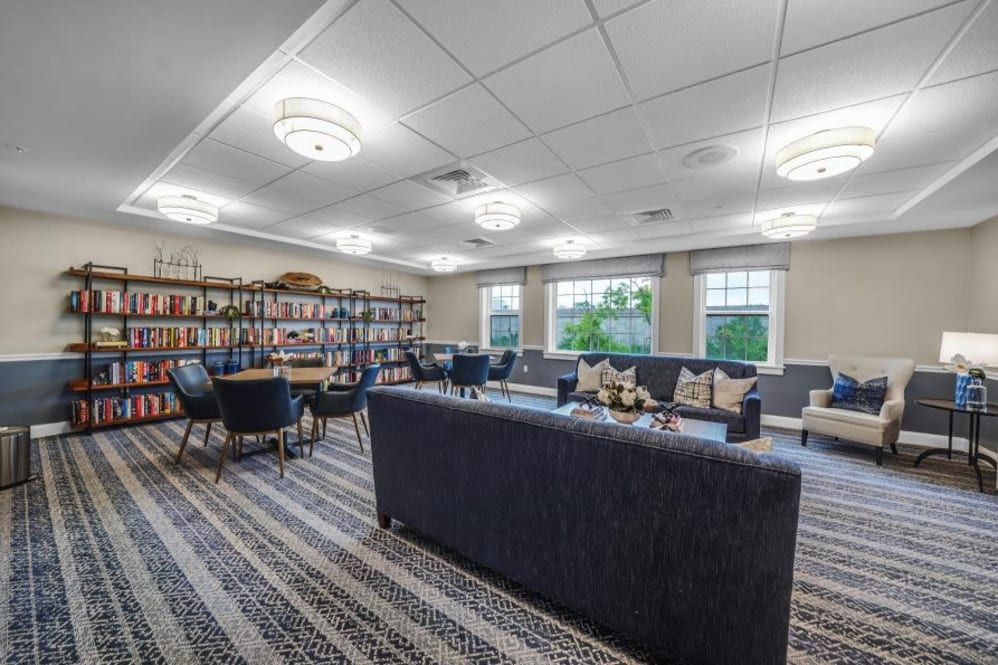 A cozy library room with comfortable seating and well-organized bookshelves.