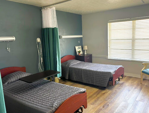A healthcare room with two beds and minimal furnishings.