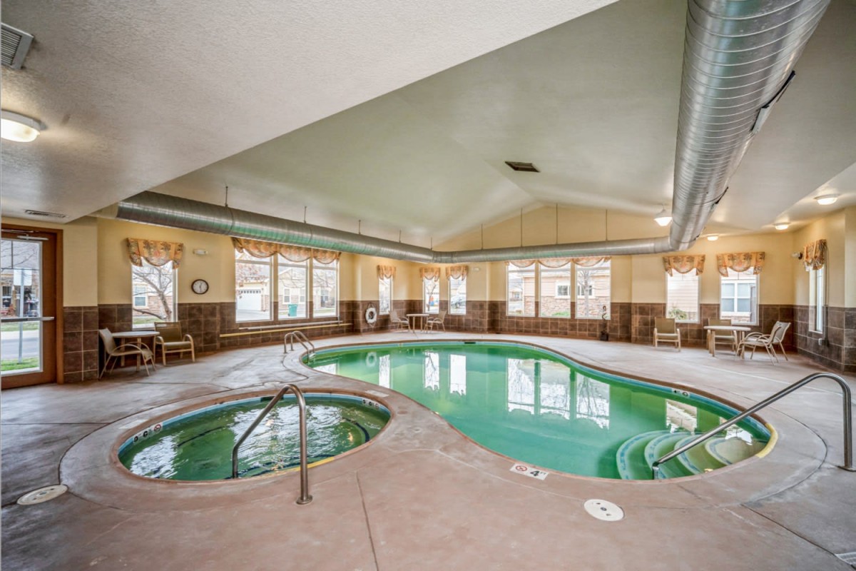 An indoor facility featuring a swimming pool and hot tub, ideal for relaxation and leisure.