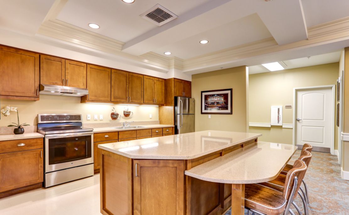 A modern kitchen with wooden cabinets, a central island, and stainless steel appliances.