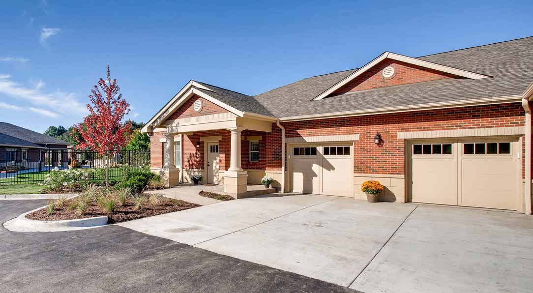 A brick house with a garage and spacious driveway.