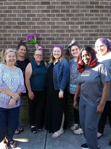 A cheerful gathering of women posing together outdoors.