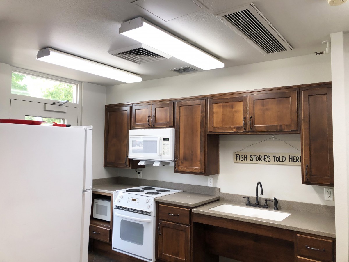 A modern kitchen with wooden cabinets and white appliances.