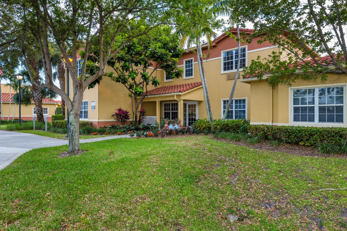A charming two-story house with a well-maintained lawn and trees in the front yard.