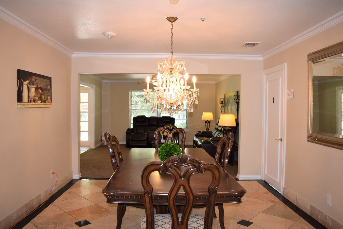 Elegant dining room with a chandelier and classic wooden furniture.