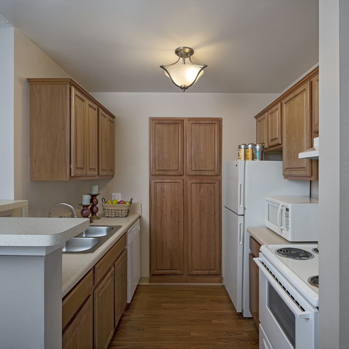 A compact kitchen with wooden cabinets and modern appliances.