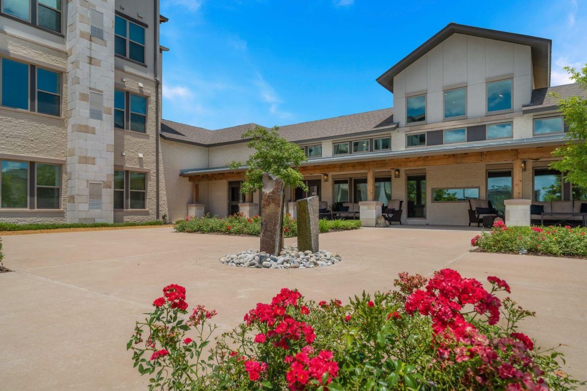A beautiful courtyard with vibrant flowers and modern architecture.
