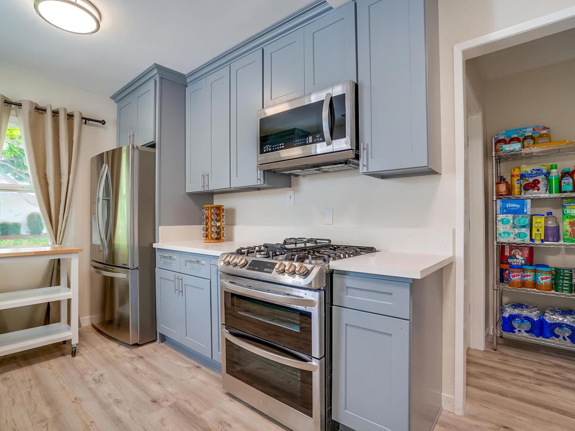 Modern kitchen with blue cabinets and stainless steel appliances.