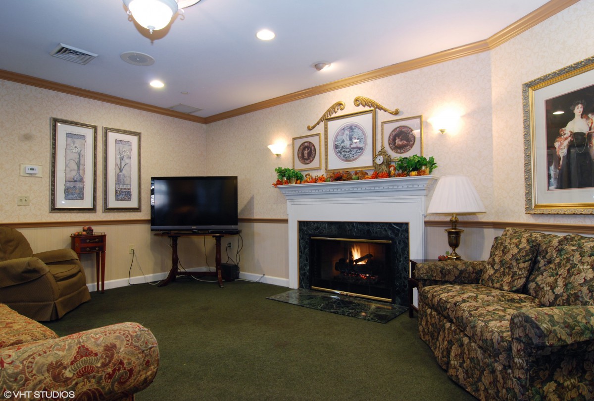 A cozy living room with a fireplace, TV, and comfortable seating.