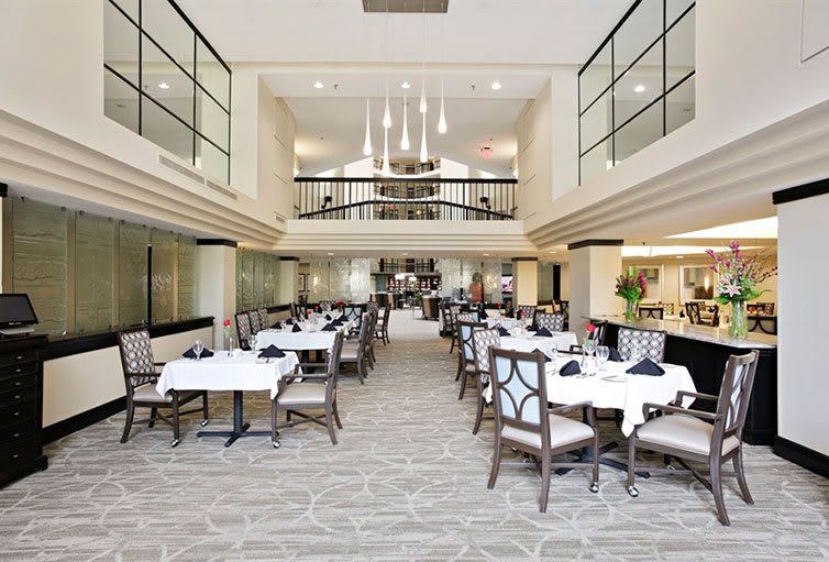 A spacious, modern dining area with well-arranged tables and elegant lighting.
