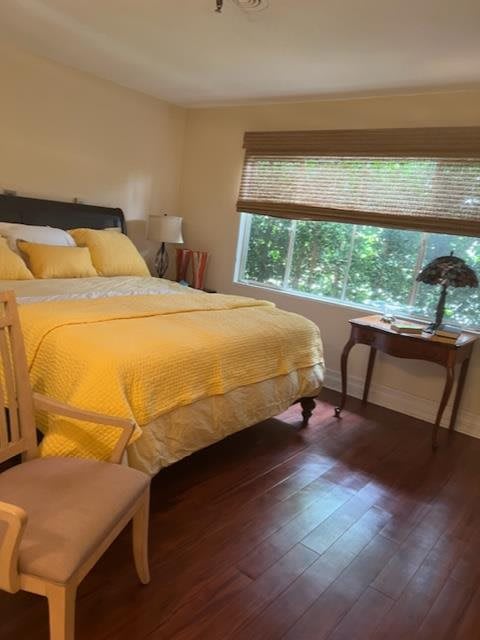 A cozy bedroom with yellow bedding and a large window.
