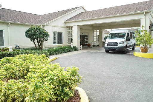 The welcoming entrance of a hospitality facility with a parked van and well-maintained landscaping.