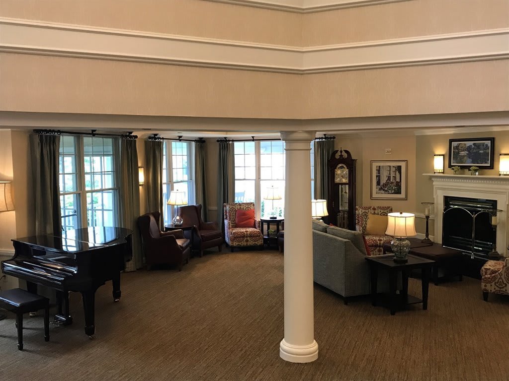 A cozy lobby interior with seating areas, large windows, and elegant lighting.