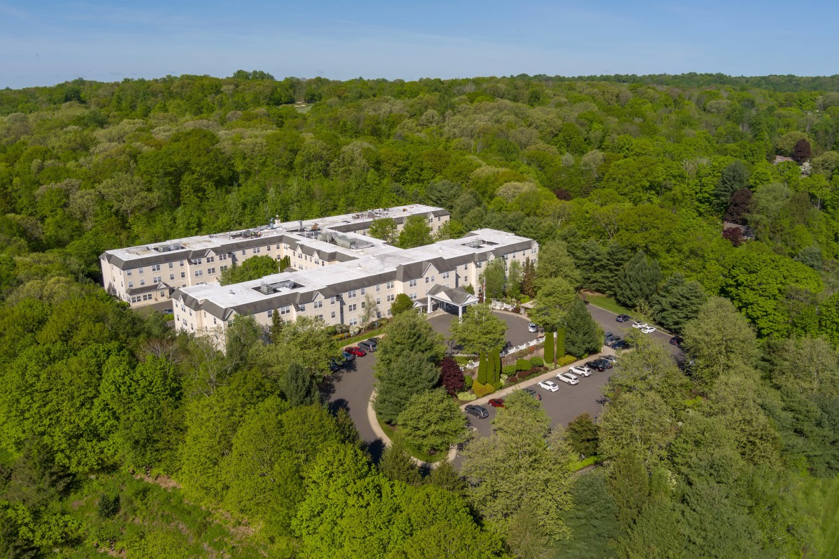 Aerial view of a large building surrounded by lush greenery.
