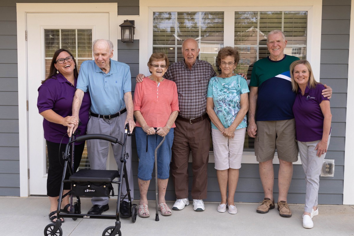 A happy group of people standing together outdoors.