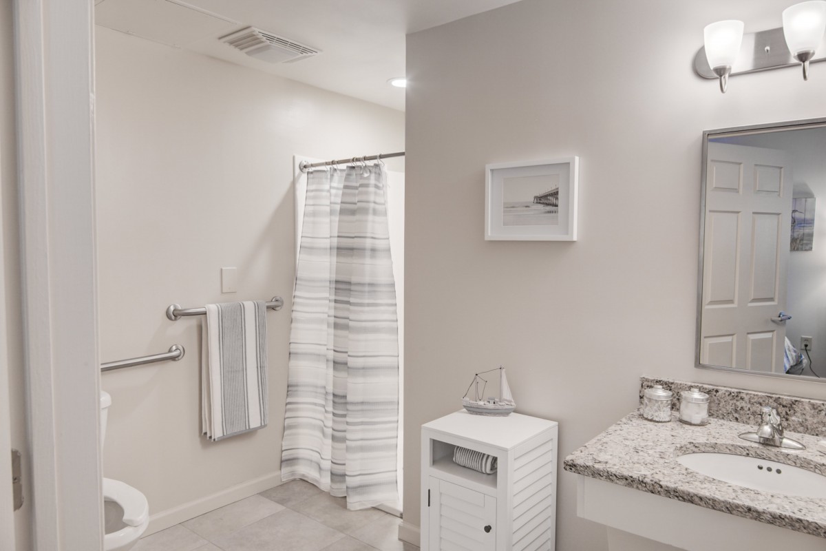 A modern and minimalist bathroom with a shower curtain, towels, and sleek design elements.