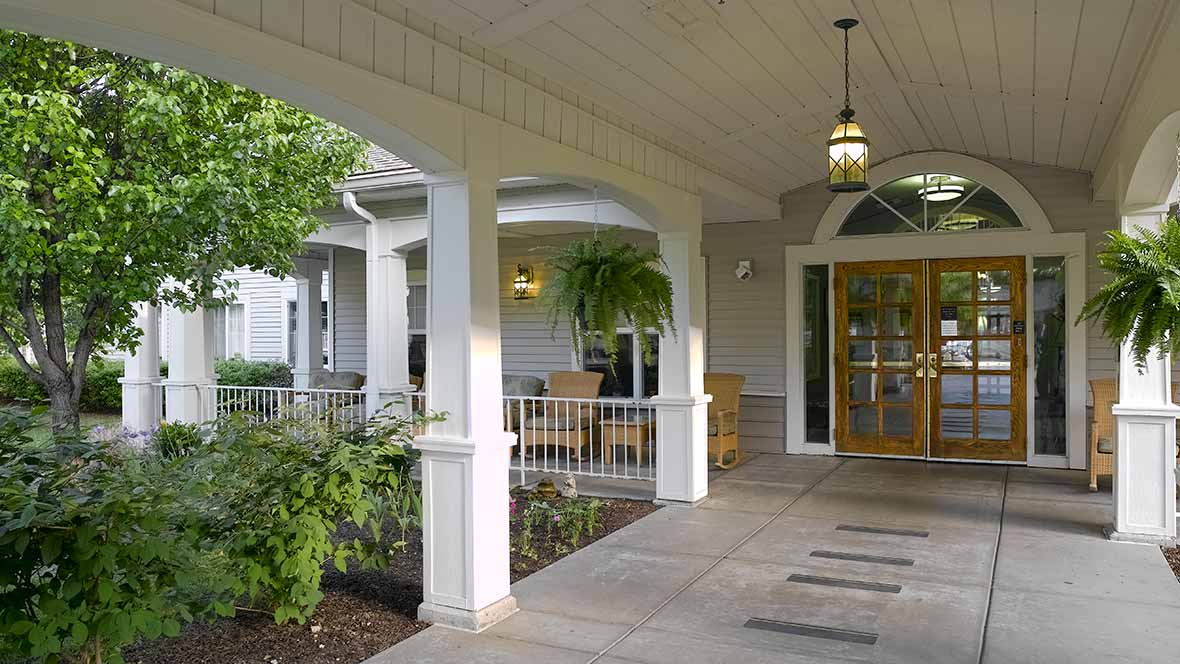 A welcoming front entrance with columns and greenery.