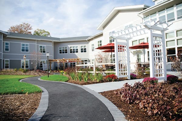 A well-landscaped residential building with a garden and pathway.