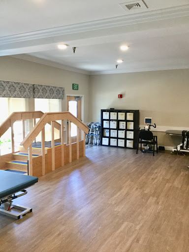 A spacious physical therapy room equipped for rehabilitation exercises.