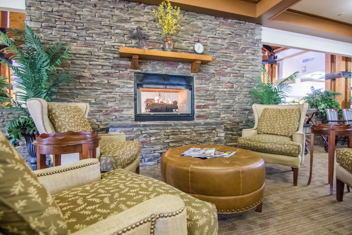 A cozy living room with a stone fireplace and comfortable seating.