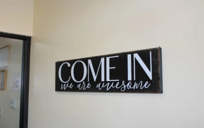 A welcoming sign reading 'Come in, we are awesome' displayed on a wall.