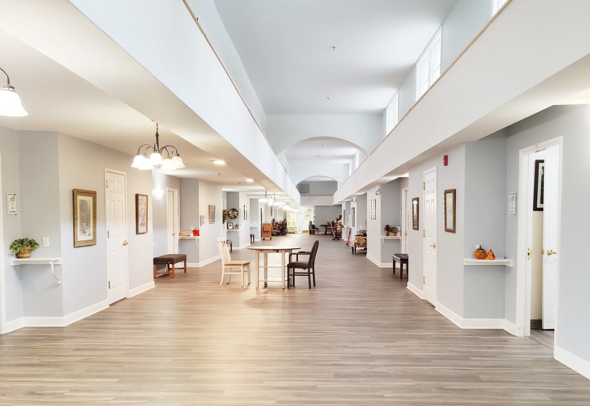 A spacious and modern hallway with light-colored walls and a wooden floor.