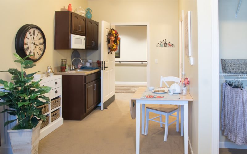 A cozy kitchen with a small dining table and chairs, featuring modern decor and appliances.