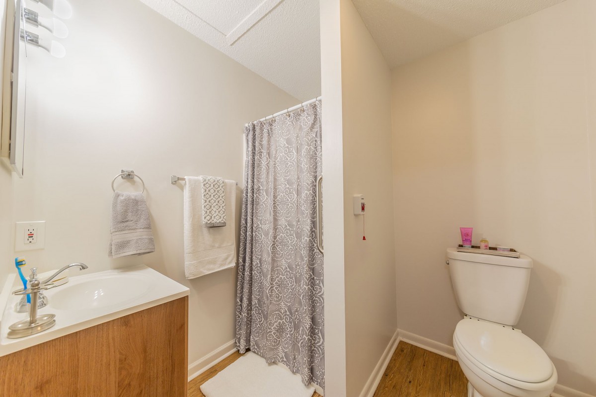 A well-organized bathroom with a shower, toilet, and sink.