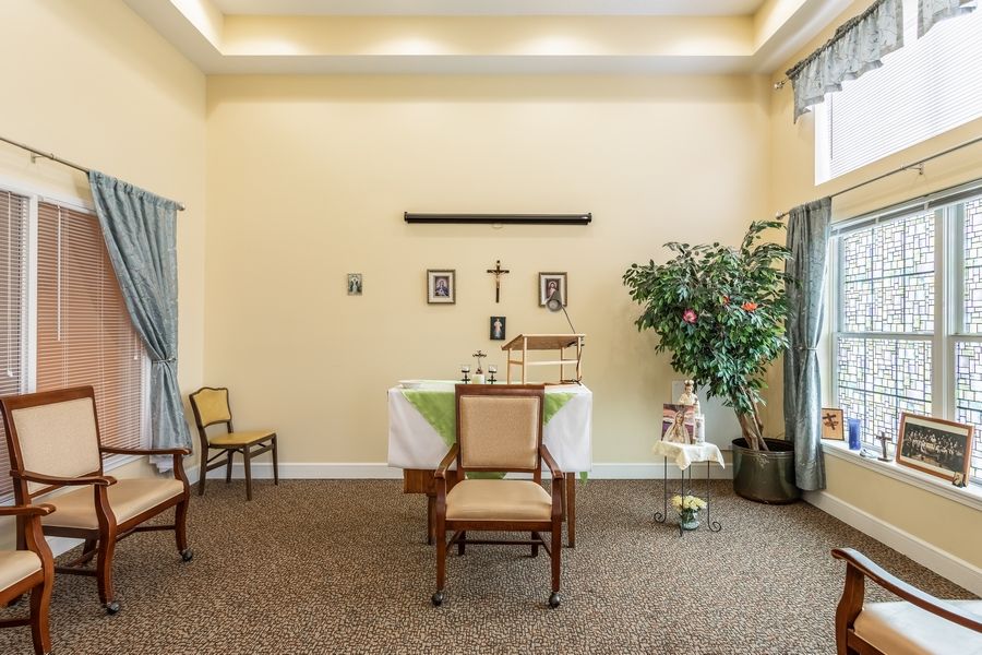 A small chapel with an altar, chairs, and religious decorations.