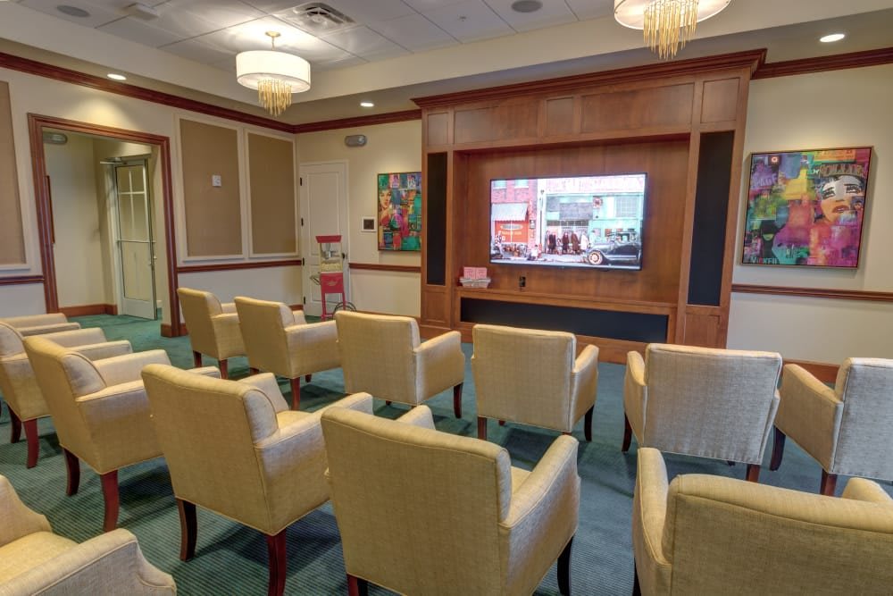 A cozy room with comfortable chairs arranged facing a television screen.