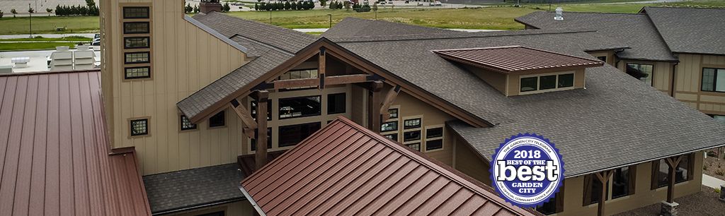 A modern building with a combination of shingle and metal roofs.