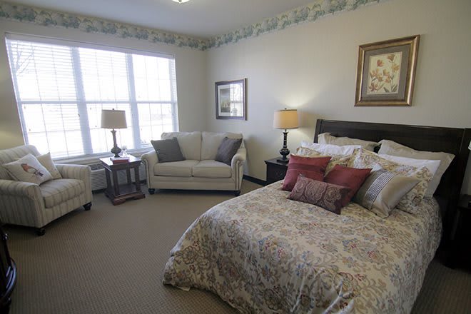 A cozy bedroom with a bed, sofa, and decorative elements.