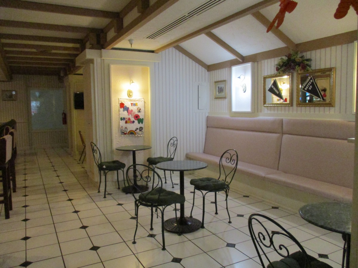 A cozy cafe interior with metal tables and chairs on a tiled floor.