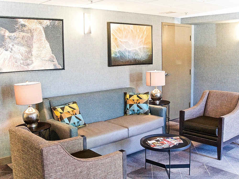 A modern living room with stylish furniture, artwork, and decorative lamps.