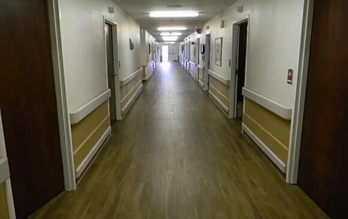 An empty, well-lit hallway in a healthcare facility.