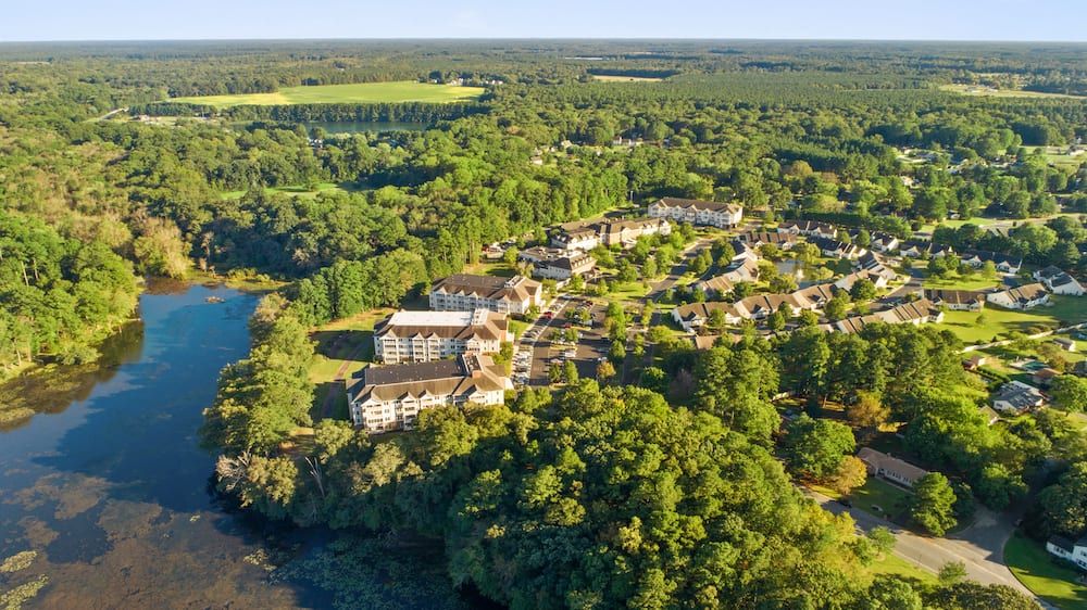 Aerial view of a residential community surrounded by lush greenery.