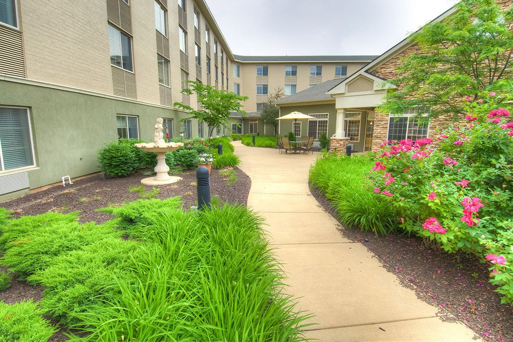 A well-landscaped garden path leading to a building entrance.