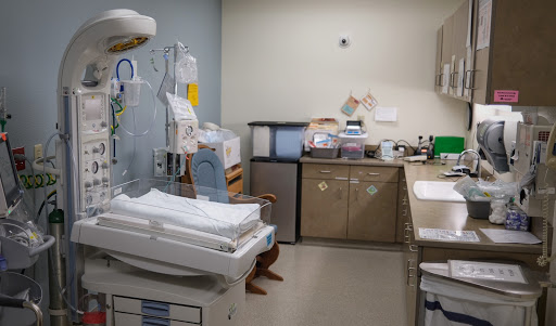 A view of a hospital room equipped for patient care, featuring various medical tools and supplies.