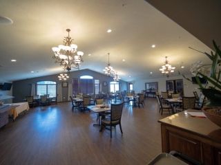 A spacious dining hall with elegant chandeliers and arranged seating.