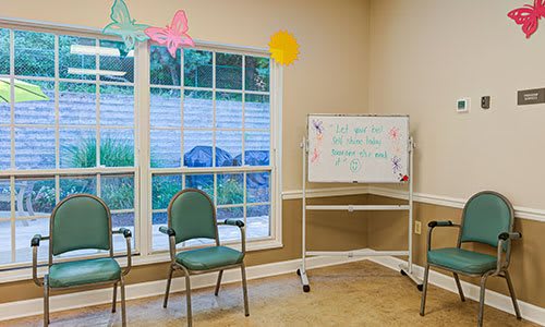 A small meeting room with chairs, a window, and a whiteboard.