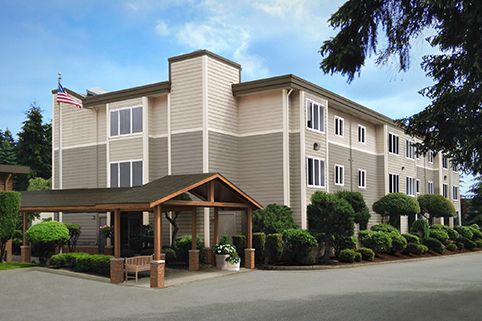 A three-story hotel building with a landscaped entrance.